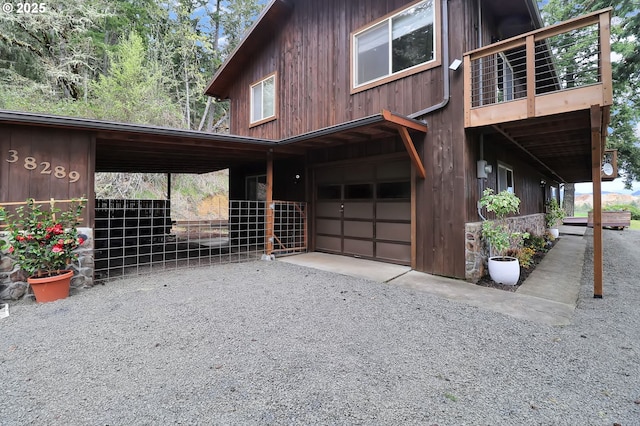 view of property exterior with a garage, a balcony, and driveway