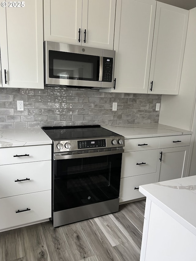 1028 Forest Heights St, Sutherlin, OR 97479 - kitchen featuring stainless steel appliances, light wood finished floors, and white cabinetry