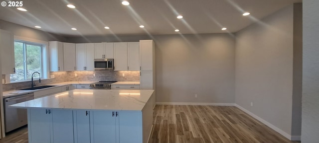 1028 Forest Heights St, Sutherlin, OR 97479 - kitchen featuring a sink, stainless steel appliances, a center island, decorative backsplash, and light stone countertops