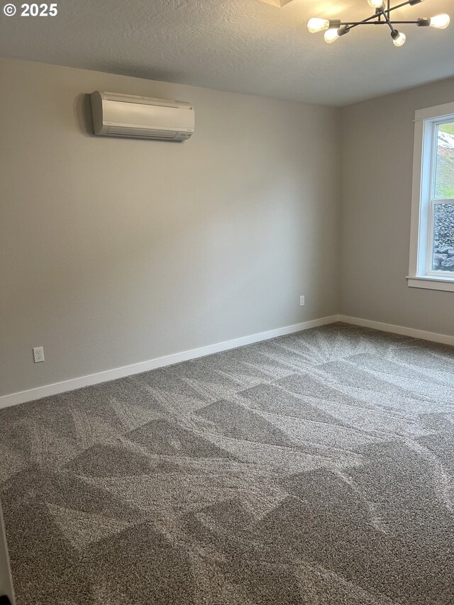 1028 Forest Heights St, Sutherlin, OR 97479 - spare room featuring a wall mounted air conditioner, baseboards, a chandelier, carpet, and a textured ceiling