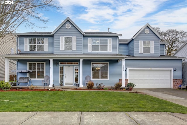 view of front of property featuring a garage, covered porch, and a front lawn