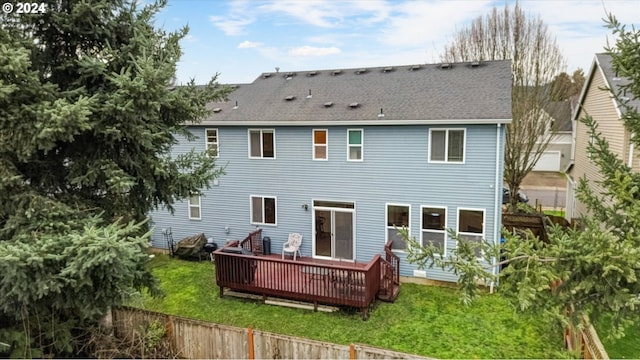 rear view of property with a wooden deck and a yard