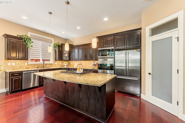 3356 NW 153rd Ter, Portland, OR 97229 - kitchen featuring stainless steel appliances, dark brown cabinetry, light stone counters, recessed lighting, and a textured ceiling