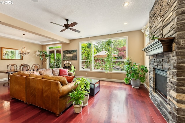 3356 NW 153rd Ter, Portland, OR 97229 - living room with a fireplace, a ceiling fan, a textured ceiling, dark wood-style floors, and a chandelier