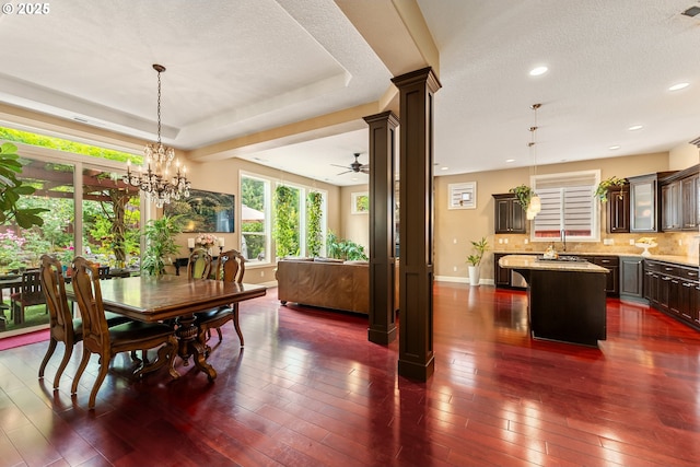3356 NW 153rd Ter, Portland, OR 97229 - dining room featuring ornate columns, a ceiling fan, a textured ceiling, dark wood-style flooring, and a tray ceiling