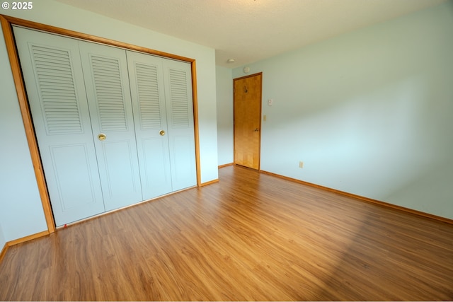 745 N 8th St, Lakeside, OR 97449 - unfurnished bedroom with wood finished floors, baseboards, and a closet