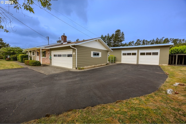 745 N 8th St, Lakeside, OR 97449 - view of property exterior featuring a garage, a chimney, and an outbuilding