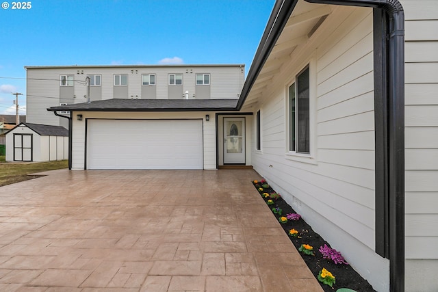 exterior space featuring a storage unit, decorative driveway, and an outbuilding