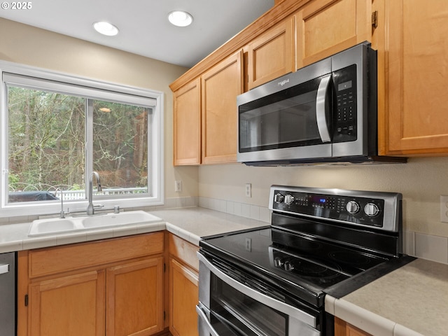 kitchen with stainless steel appliances, a sink, and recessed lighting