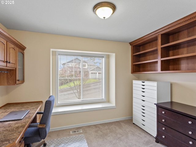 unfurnished office with light carpet, visible vents, and baseboards