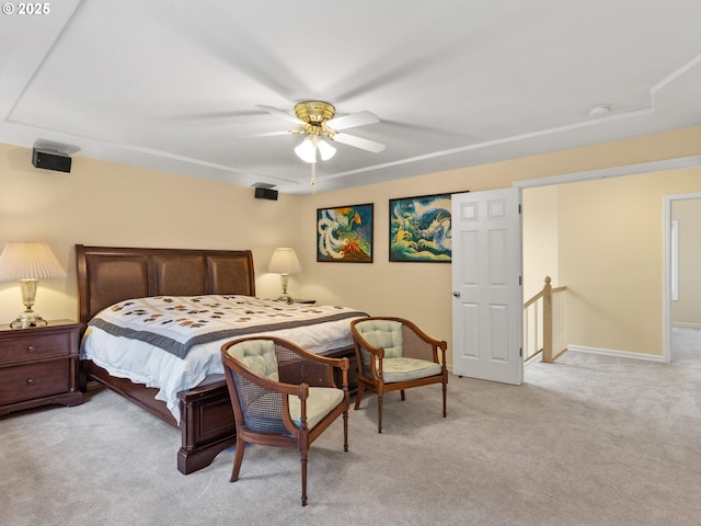 bedroom featuring light colored carpet, ceiling fan, and baseboards