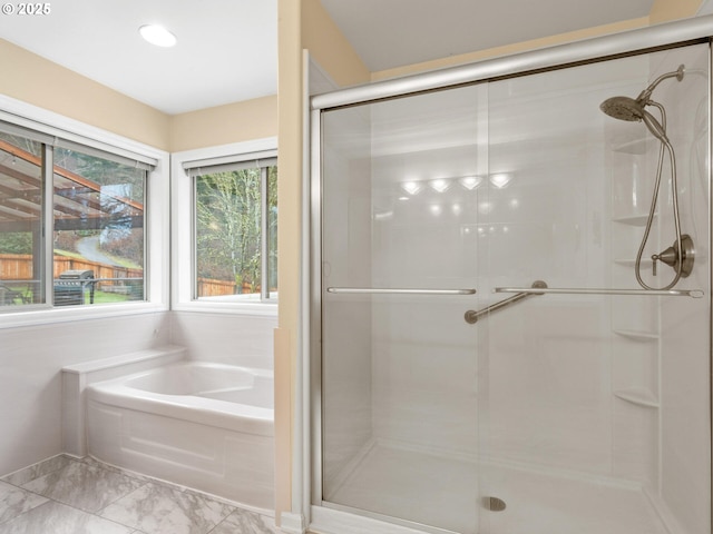 bathroom featuring marble finish floor, a shower stall, and a bath