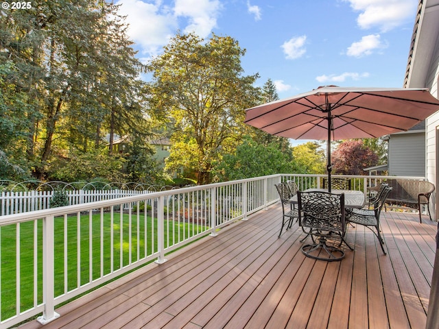 wooden deck with fence, outdoor dining area, and a yard