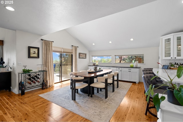 dining room with light wood-style floors, recessed lighting, and lofted ceiling