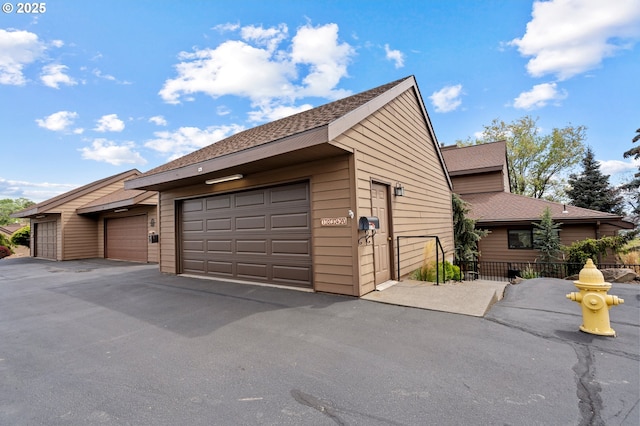 view of property exterior with roof with shingles and fence