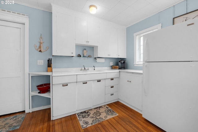 kitchen featuring white cabinetry, freestanding refrigerator, light countertops, and open shelves