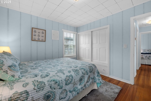 bedroom with dark wood-style floors and a closet