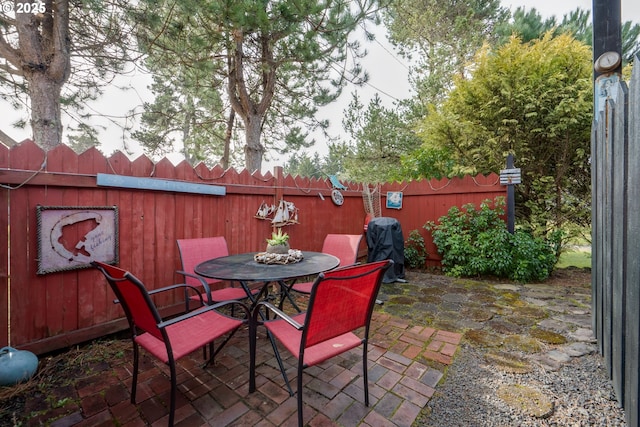 view of patio / terrace featuring a grill, fence, and outdoor dining area