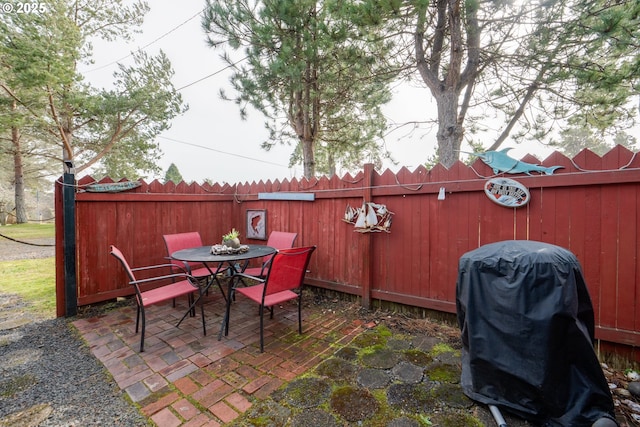 view of patio featuring outdoor dining space, grilling area, and a fenced backyard