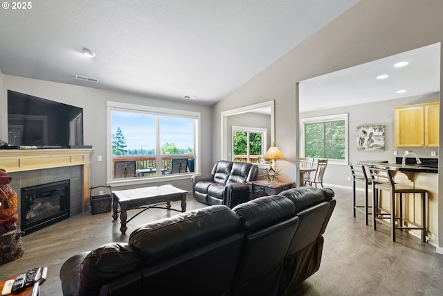 862 NW Edgewood Pl, Albany, OR 97321 - living room with light wood finished floors, lofted ceiling, a tile fireplace, recessed lighting, and baseboards