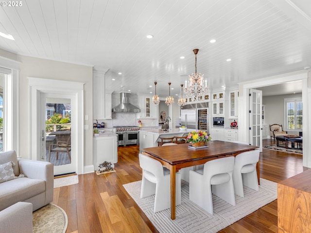 dining area with a chandelier, wood finished floors, recessed lighting, and wood ceiling