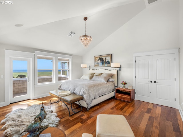 bedroom with access to outside, high vaulted ceiling, wood finished floors, and a chandelier