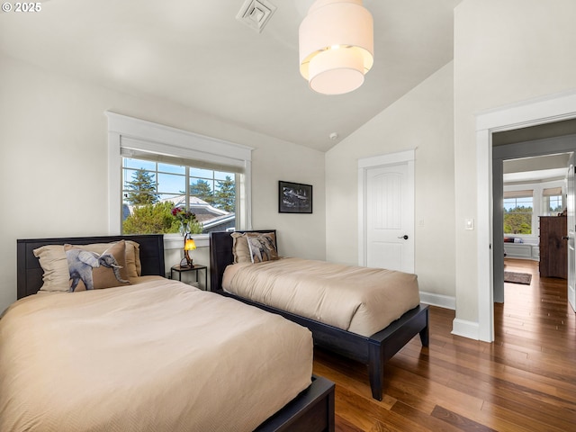 bedroom with lofted ceiling, wood-type flooring, and baseboards