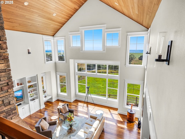 living room with high vaulted ceiling, hardwood / wood-style flooring, wood ceiling, healthy amount of natural light, and baseboards