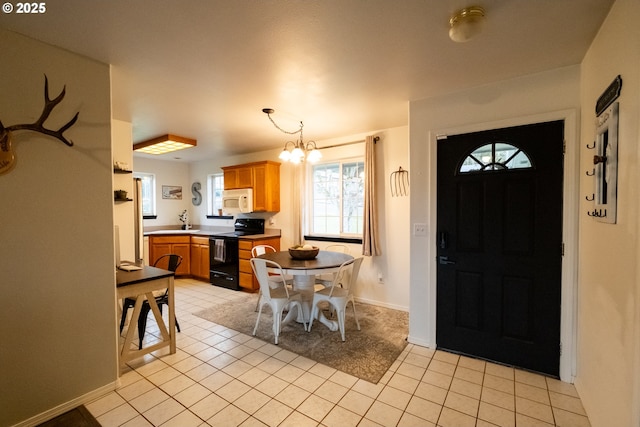 tiled foyer entrance with an inviting chandelier