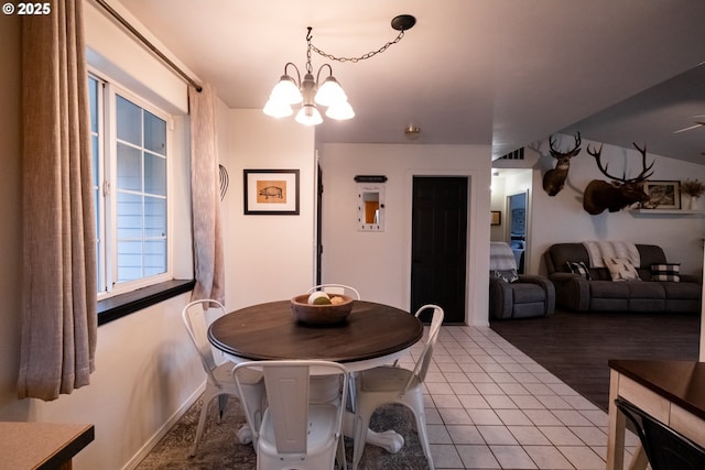 tiled dining space featuring a chandelier