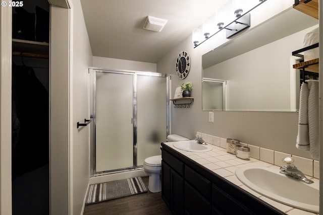 bathroom with a shower with shower door, vanity, toilet, and hardwood / wood-style floors