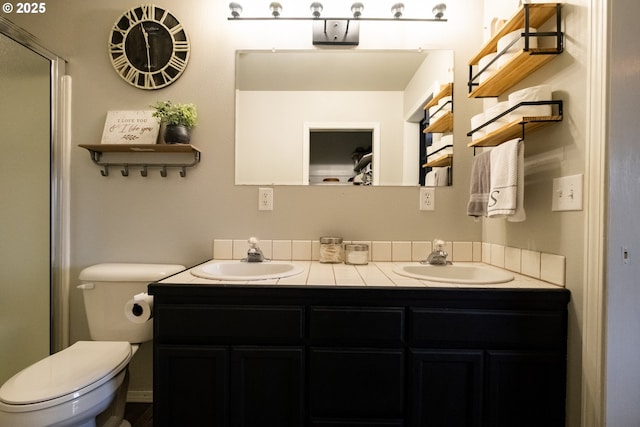 bathroom featuring toilet, vanity, and walk in shower