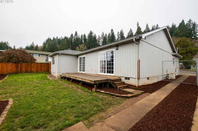 rear view of property with a lawn and a wooden deck