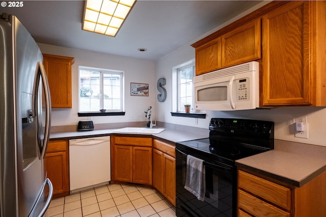 kitchen with light tile patterned flooring, sink, and white appliances