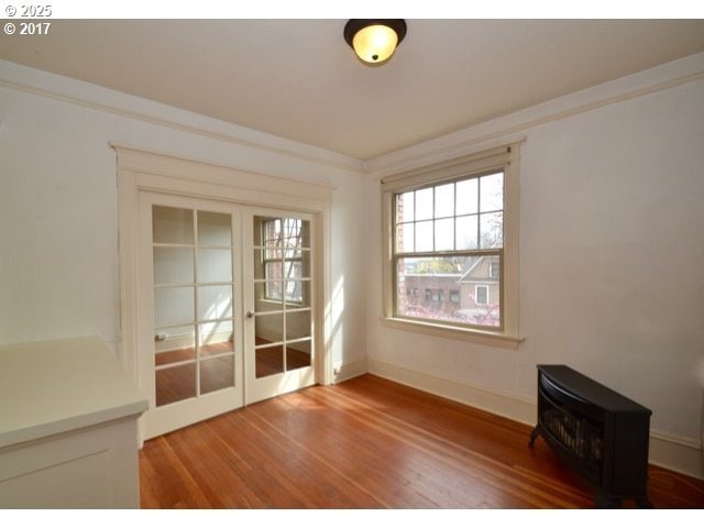 unfurnished room featuring light wood-style floors and crown molding