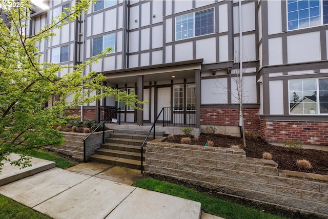 entrance to property featuring brick siding and covered porch
