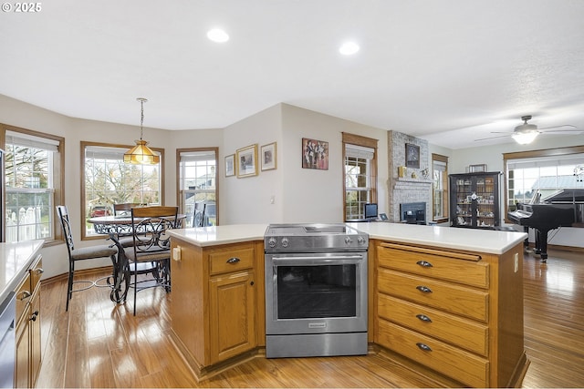14504 SE Old Barn Ln, Damascus, OR 97089 - kitchen featuring appliances with stainless steel finishes, light countertops, a fireplace, ceiling fan, and recessed lighting