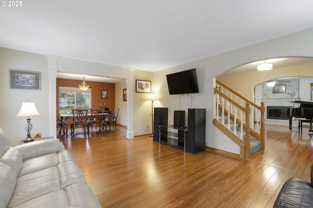 14504 SE Old Barn Ln, Damascus, OR 97089 - living room featuring light wood-style flooring, a fireplace, stairs, and baseboards