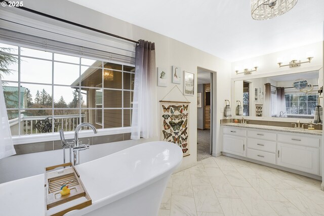 14504 SE Old Barn Ln, Damascus, OR 97089 - full bath featuring double vanity, a freestanding tub, and marble finish floors