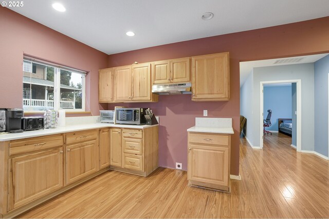 14504 SE Old Barn Ln, Damascus, OR 97089 - kitchen with light brown cabinets, under cabinet range hood, stainless steel microwave, light wood finished floors, and light countertops