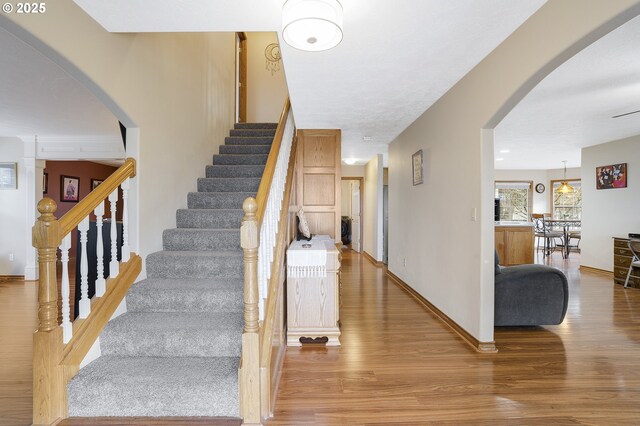14504 SE Old Barn Ln, Damascus, OR 97089 - stairway featuring wood finished floors, arched walkways, and baseboards