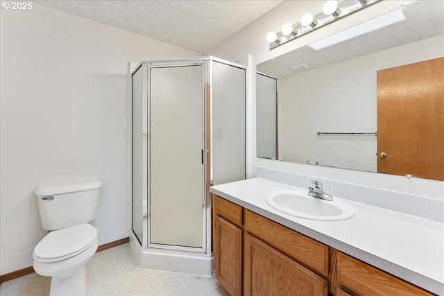 bathroom featuring a textured ceiling, toilet, vanity, tile patterned floors, and a stall shower