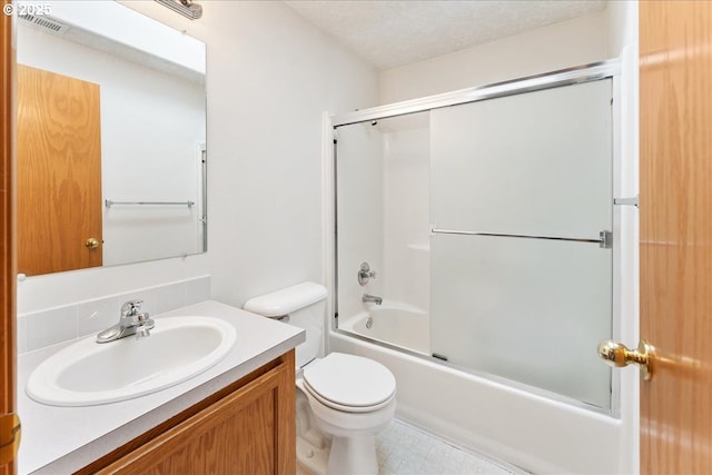 bathroom featuring visible vents, bath / shower combo with glass door, toilet, a textured ceiling, and vanity