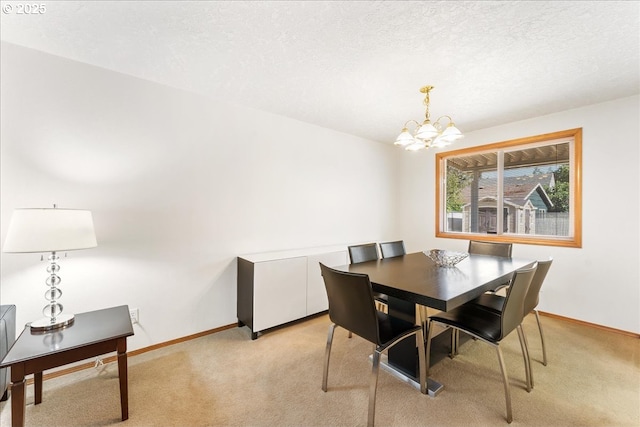 dining area with light colored carpet, a notable chandelier, a textured ceiling, and baseboards