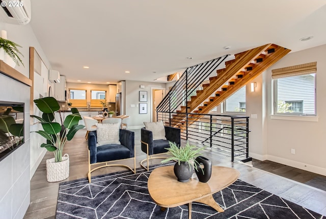 7952 SE 6th Ave, Portland, OR 97202 - living area with wood finished floors, baseboards, an AC wall unit, stairs, and recessed lighting