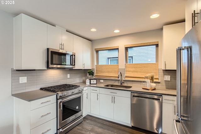 7952 SE 6th Ave, Portland, OR 97202 - kitchen with high end appliances, a sink, dark wood finished floors, tasteful backsplash, and white cabinets