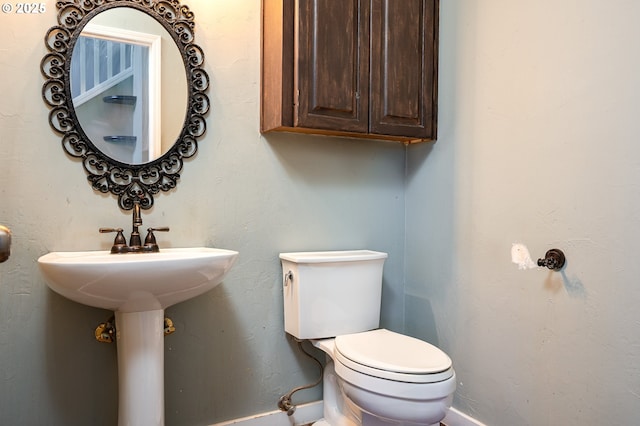 bathroom with baseboards and toilet