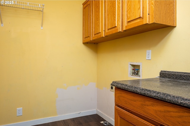 washroom featuring baseboards, hookup for a washing machine, dark wood-style floors, electric dryer hookup, and cabinet space