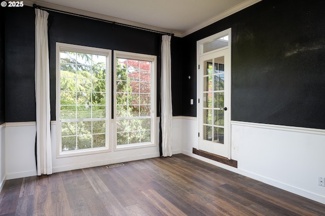 entryway featuring crown molding, wainscoting, visible vents, and dark wood-style floors