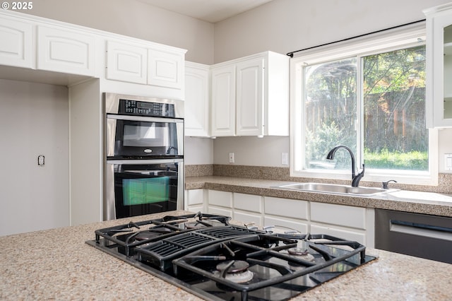 kitchen with light countertops, a sink, white cabinetry, and stainless steel appliances